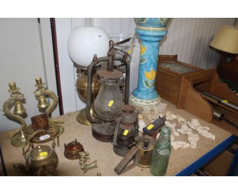 An oil lamp; two tea lamps; a blow lamp and an old glass bottle