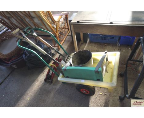 A plastic garden wheelbarrow; a fork; spade; bucket; kneeler etc 