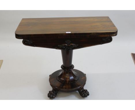 Early Victorian rosewood fold-over card table on tapering column support, with circular base and carved paw feet, 35.5ins wid