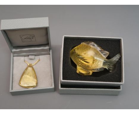Small Lalique amber glass model of a fish, 2.5ins wide, in original box together with a Lalique amber glass pendant, in origi