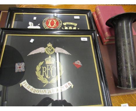 Two framed regimental needlework pictures in ebonised and gilt slip frames, 15ins x 19ins each, two canvas bound books ' A Hi