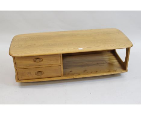 Ercol coffee table, the figured top above an alcove and two drawers raised on casters, 49ins x 16ins16ins high x 49ins wide x