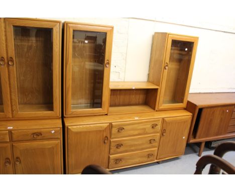 Modern Ercol side cabinet, the superstructure with two glazed cupboard doors enclosing adjustable glass shelves flanking a ce