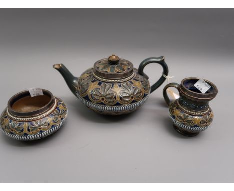 Late 19th Century Doulton Lambeth stoneware three piece tea service with typical stylised floral decoration, the silver mount