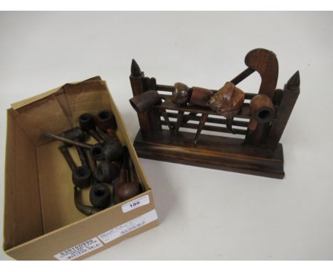 Wooden pipe rack in the form of a gate together with a small quantity of various pipes 