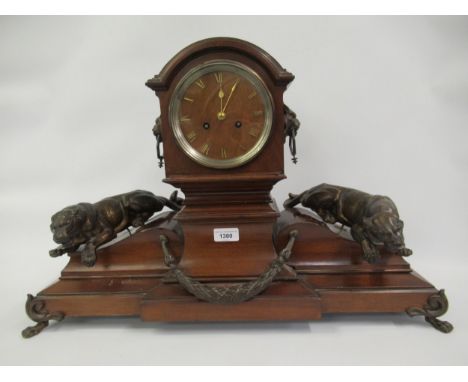 Early 20th Century mahogany mantel clock of architectural form, the broken arch top above a wooden dial with Roman numerals, 