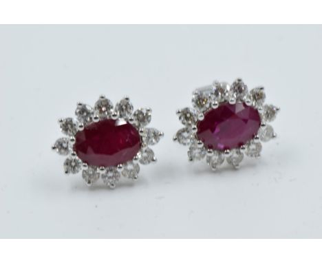 Pair of 18ct white gold oval ruby and diamond cluster ear studs 