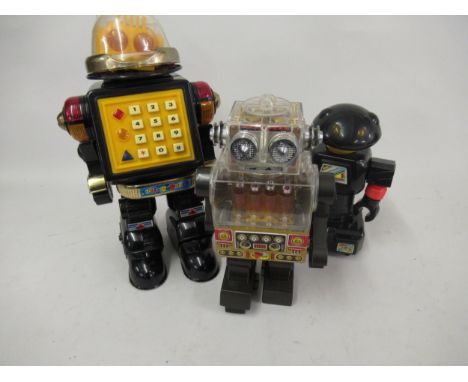 Japanese tin plate and plastic robot together with two other plastic robots 