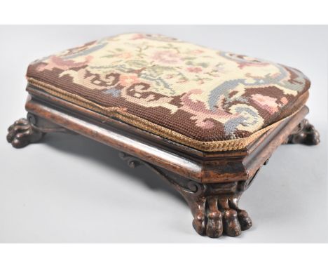 A Victorian Carved Wooden Footstool with Four Claw Feet and Tapestry Upholstery, 36x29cms 