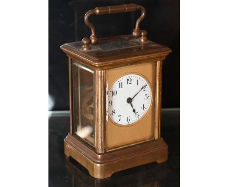 A miniature Mignon brass carriage clock with white enamel dial, 8 cm high, a/fone piece of side glass missing