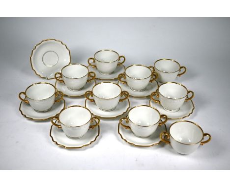 Ten Augarten (Austria) two-handled cups with nine saucers, with gilt handles and rims