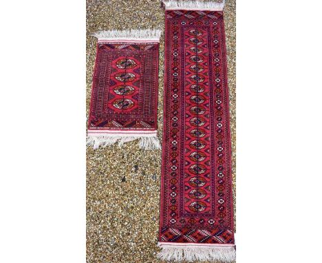 An Afghan Turkman runner, red ground 200 cm x 52 cm to/w a small rug of conforming design, 92 cm x 64 cm (2)