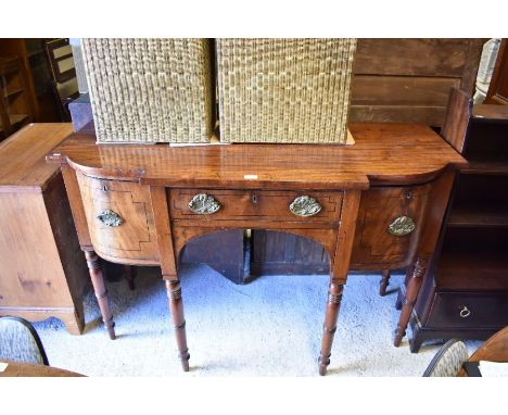 A George III mahogany breakfront sideboard, centred by a drawer flanked by deep drawers either side, raised on six ring turne