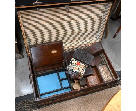 A vintage canvas covered wooden bound trunk containing collection of small wooden boxes, some carved examples