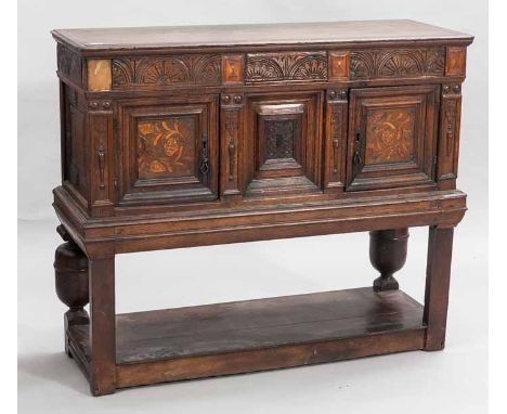 OAK BUFFET CUPBOARD
of 17th century design, the moulded cornice with carved frieze below, cupboard beneath enclosed by floral