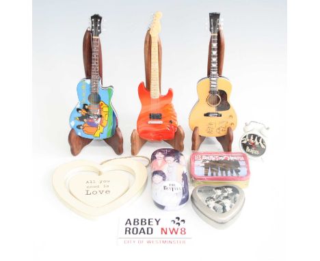 A collection of assorted Beatles memorabilia, to include three miniature guitars, travel clock, glasses case and tins etc.