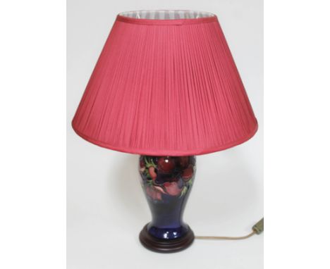 A Moorcroft pottery table lamp with wooden base and shade, height (including shade) 54cm.Condition: minor dirt/stains to lamp
