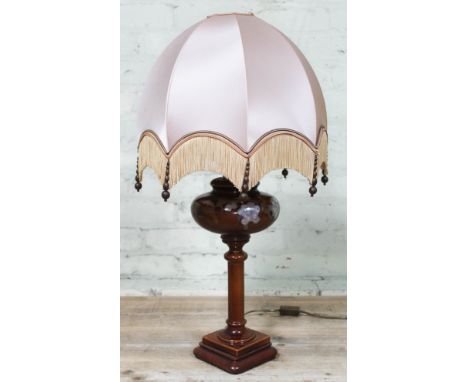 A French pottery table lamp by Louis Drimmer, in the form of an oil lamp with floral decoration, with shaped shade having tas