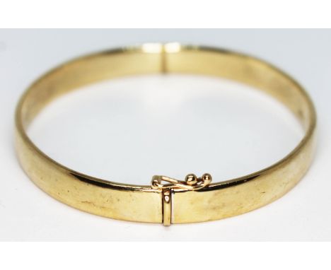 An Italian 9ct gold bangle, marked '9K', approx. diam. 55mm, wt. 11.5g.Condition: very good, no damage or repairs, hinge and 