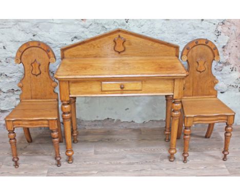 A Victorian light oak hall table with architectural arched back, single drawer and turned legs, with a pair of matching hall 