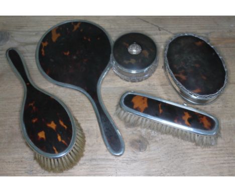 A hallmarked silver and tortoiseshell dressing table set comprising two brushes, hand mirror, trinket box and cut glass jar. 