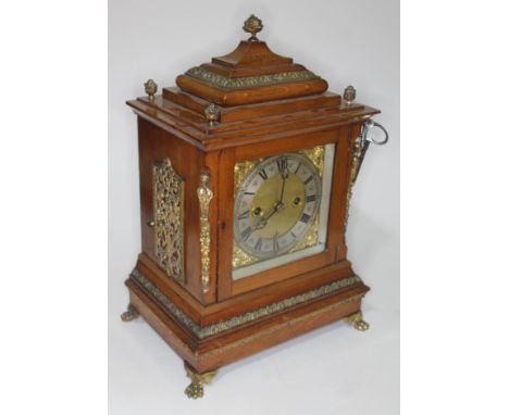 An early 20th century gilt brass mounted oak mantle clock, steel and brass dial with Roman numerals and date aperture, double