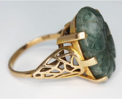 A hallmarked 9ct gold ring set with a carved jade coloured stone, gross wt. 9.4g, size T.  