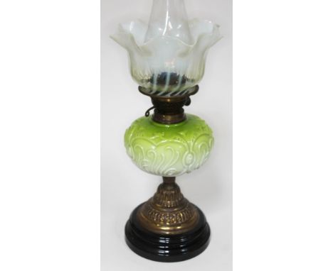 A Victorian oil lamp having twist vaseline glass shade with crimped rim, green and white opaque glass reservoir, embossed gil