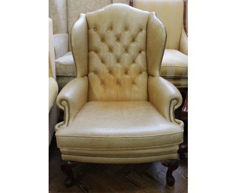 A reproduction leather button back wingback armchair