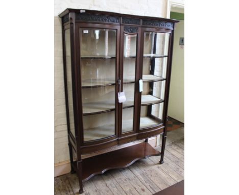 A reproduction mahogany display cabinet with under tier and bow fronted glazed door