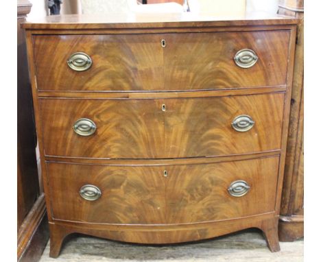 A Georgian mahogany three drawer, bow front chest with plate handles, standing on splayed feet