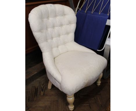 A modern cream upholstered button back chair