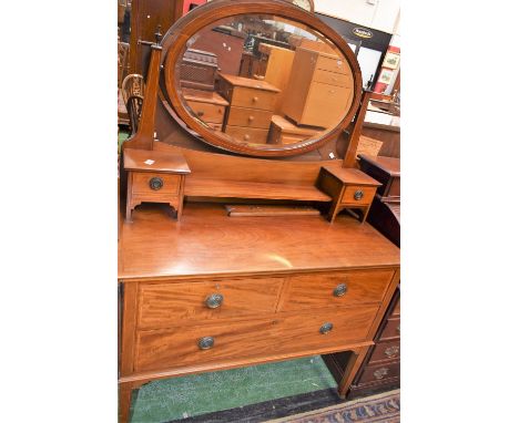 An early 20th century mahogany dressing table, the shaped superstructure with an oval mirror flanked by a pair of small drawe