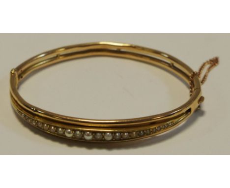 A Victorian 9ct gold hinged bangle set with graduated seed pearls 12.5g