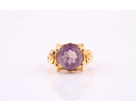 A French amethyst dress ring, the yellow metal mounted round mixed cut 12.5mm amethyst, claw set surrounded by four flowerhea