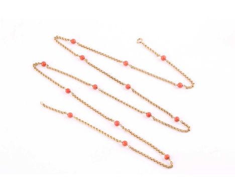 A yellow precious metal and coral bead necklace, textured doubled belcher links, with compressed coral spacer beads averaging