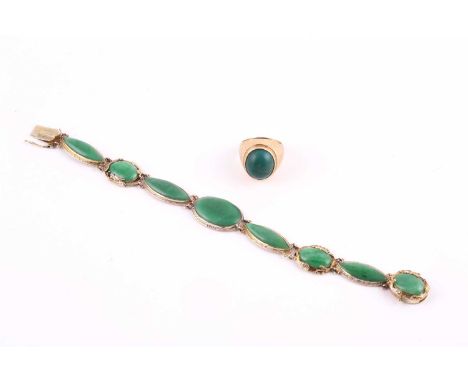 A jade bracelet, with oval and navette shape panels, to an ornate yellow precious metal mount, stamped '14', 17cm long, 17.2 