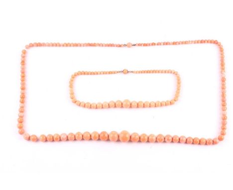 Two early 20th century light-orange coral bead necklaces, the longer necklace loosely strung with 125 slightly-mottled beads 