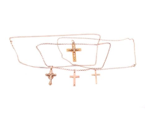A collection of three 9ct gold crosses, comprising a crucifix on chain, two crosses on chains, together with an unmarked yell
