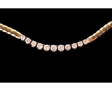 A flat snake chain necklace set with eleven graduated brilliant-cut diamonds in white metal, with the chain being yellow meta