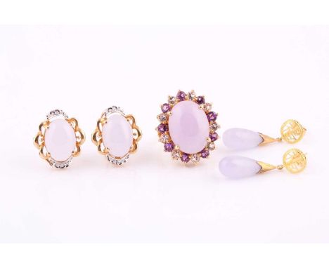 Lavendar colour jade cabochon ring, within a purple and white paste set surround, yellow precious metal mount and shank, stam