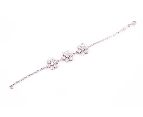 A contemporary diamond set hayseed link bracelet, with round brilliant cut diamonds set into three spaced flowers along a whi