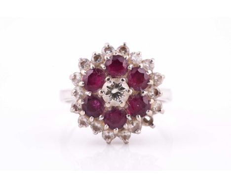 An 18ct white gold, ruby and diamond flower-head cluster ring, centred with a small round brilliant diamond within six round 