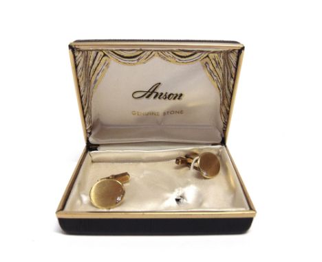 A PAIR OF DIAMOND SET CUFFLINKS  stamped '14K', the mat finished oval panels set to one side with a single cut diamond, cased