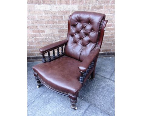 A VICTORIAN MAHOGANY FRAMED BUTTON UPHOLSTERED ARMCHAIR  the arms supported on spindle turned uprights 