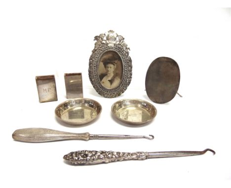AN OVAL PHOTOGRAPH FRAME  with cartouche and cherub movement, seemingly unmarked; a pair of small unmarked circular dishes; a