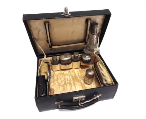 A CASED TRAVELLING TOILET SET  the case fitted with five silver mounted toilet bottles, two manicure items with silver handle