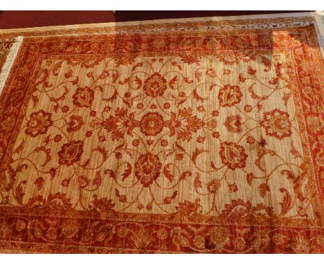 A Ziegler style carpet with central floral design on a beige ground contained by red ground border, 230cm x 160cm