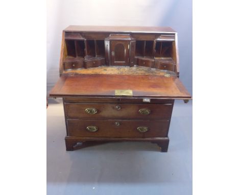A regency mahogany bureau with drop down flap enclosing fully fitted interior above one long, two short and two further long 