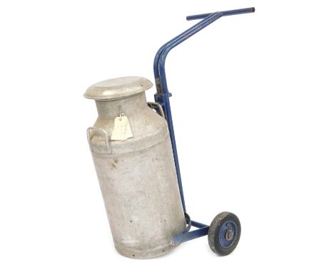 A mid century Milk Marketing Board aluminium milk churn, serial no J4316, with a blue painted metal trolley.